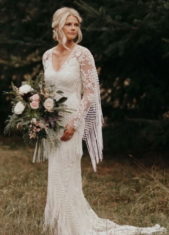 Jenna boho lace sheath gown with a V-neckline, a capelet with long fringe and a train