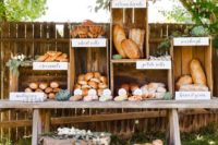 a bread and pastry station made of a rustic table and some crates placed on each other for a farmhouse wedding