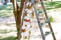 21 a ladder seating plan with escort cards and succulents for a rustic wedding