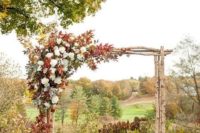 21 a rustic fall wedidng arch of wood branches and lush leaves and white blooms for decor