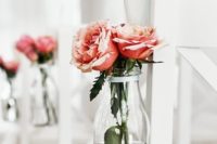22 decorate the aisle chairs attaching Ensidig vases with blooms to them
