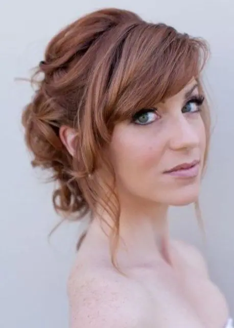a curled low updo with bangs, waves and a side fringe for medium length and long hair