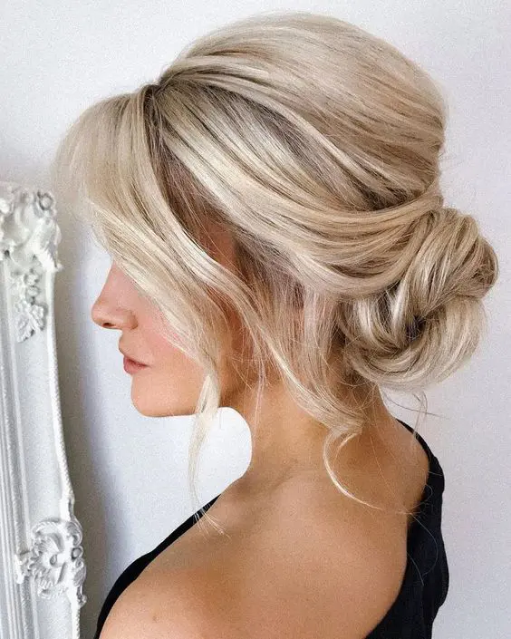 a beautiful and chic messy twisted low bun with a bump, some face-framing waves down is a lovely idea