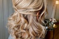 a beautiful and timeless half updo with a bump on top and waves down is a stylish idea for medium hair
