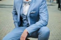 a beautiful dusty blue three-piece suit, a light blue bow tie, brown shoes and a white shirt are a cool and chic look