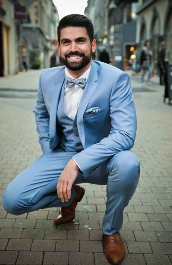 a beautiful dusty blue three-piece suit, a light blue bow tie, brown shoes and a white shirt are a cool and chic look