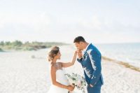 a bold blue groom’s suit paired with a white shirt and brown shoes for a blue beach wedding