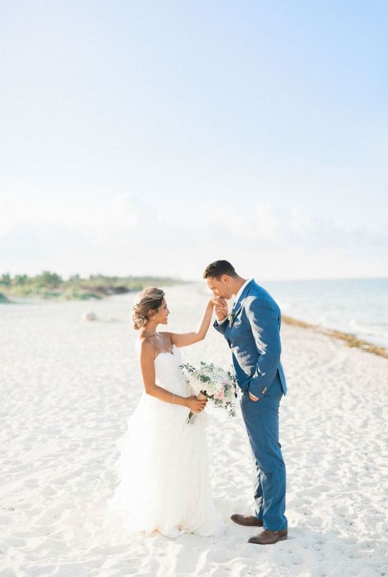 a bold blue groom's suit paired with a white shirt and brown shoes for a blue beach wedding