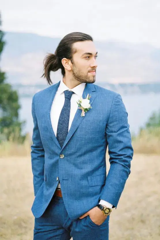 a bright blue linen suit, a white shirt, a navy printed tie and a boutonniere are a cool outfit for a summer wedding