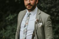 a casual groom’s look with a white shirt, creamy pants, a grey blazer, a printed tie and black suspenders