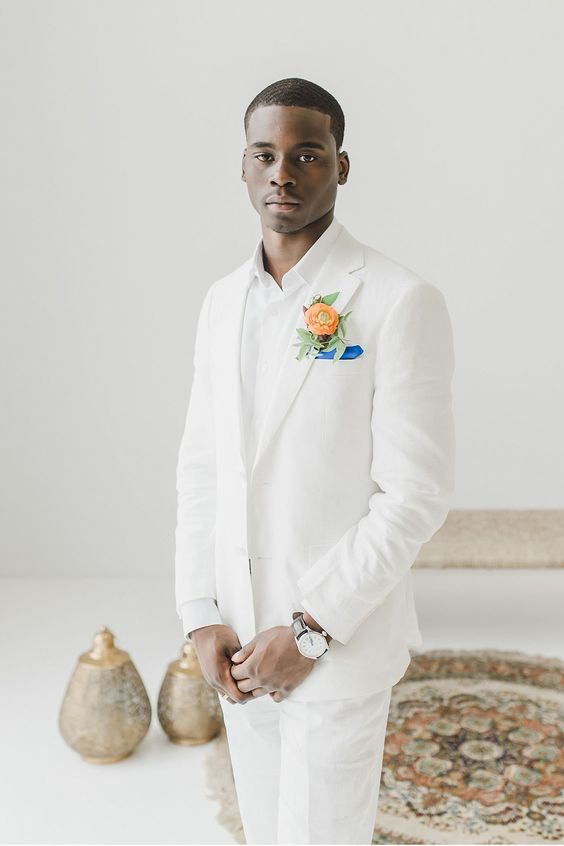 a chic groom's look with a white suit, a white shirt, a bold boutonniere and a handkerchief is amazing for a tropical wedding