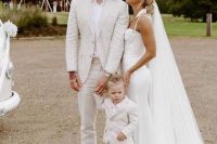 a chic summer groom’s look with a neutral linen suit, a white shirt, a neutral hat and white sneakers