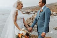 a coastal groom’s look with a blue suit, a white shirt, a rust tie, borwn shoes and a bold boutonniere is amazing for the fall