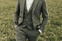 a cool groom’s outfit with a grey wool three-piece pantsuit, a white shirt, a black bow tie, a chain is wow