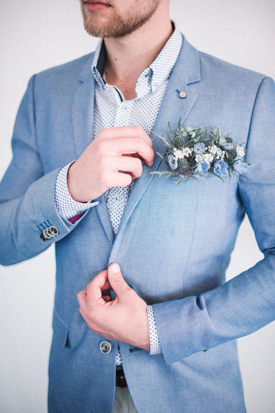 a delicate coastal groom's look with a light blue suit, a polka dot shirt, a blue flower pocket square is amazing