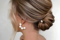 a dimensional low chignon with a volume on top and some face-framing locks is adorable