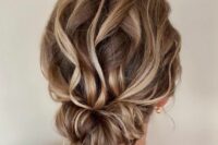 a dreamy wavy twisted low updo with a wavy top and some waves down looks very eye-catching and bold