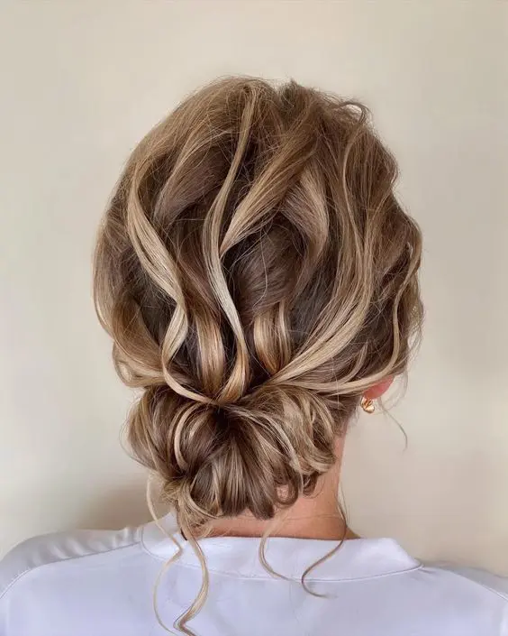 A dreamy wavy twisted low updo with a wavy top and some waves down looks very eye catching and bold