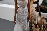 a fabulous fully beaded semi sheer fitting wedding dress with a corset-like top and thick straps plus a train is amazing