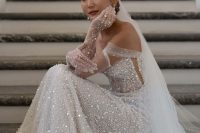 a gorgeous off the shoulder fully embellished wedding dress, a cathedral veil and long embellished gloves