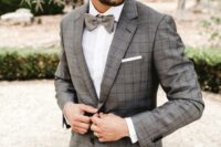 a grey plaid pantsuit, a white shirt, a grey bow tie are a stylish combo for a groom, in any season