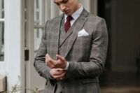 a grey plaid three-piece suit, a white shirt, a burgundy bow tie and a brown belt for a touch of vintage