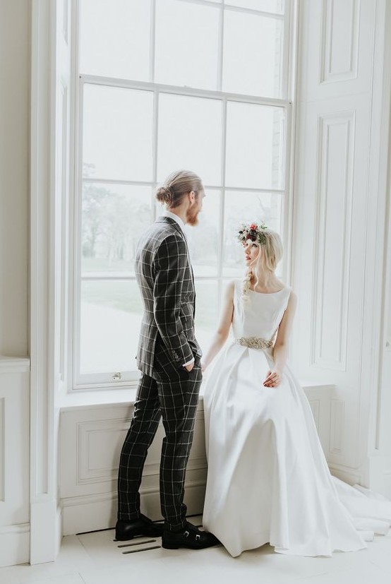 a grey windowpane print suit, a white shirt, black shoes and black socks for a bold modern groom's look