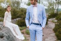 a light blue suit, a bright blue belt, a white shirt and sneakers and a pink printed bow tie