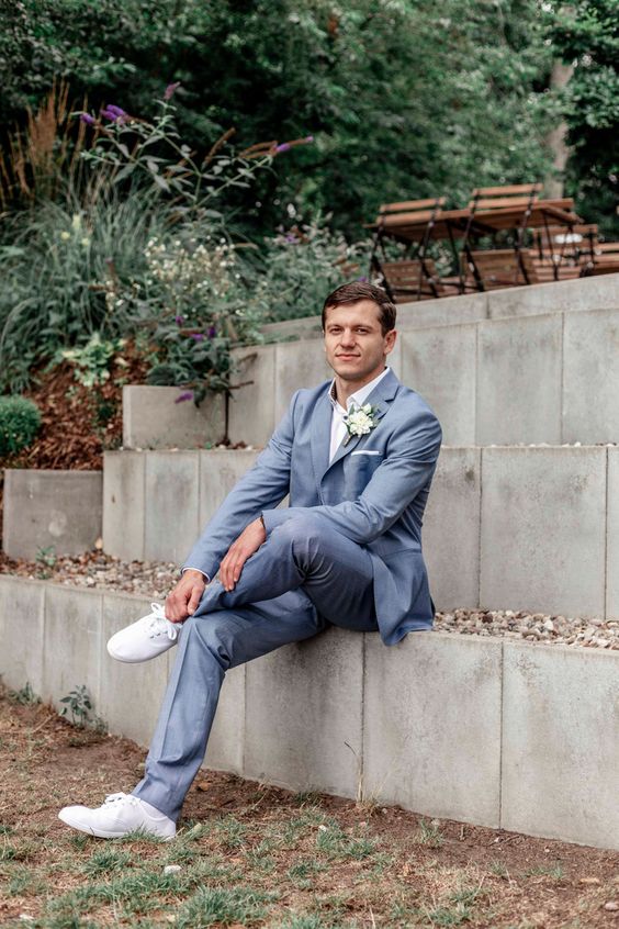 a lovely blue grey suit, a white shirt, a boutonniere, white sneakers are amazing for spring or summer
