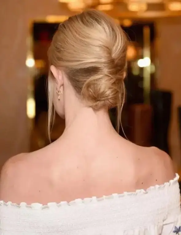 a low French twisted updo with a volume on top and locks down is a stylish idea for a effortlessly chic bride