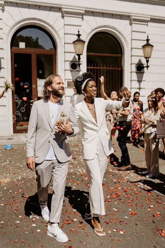 a minimalist groom's outfit with a dove grey pantsuit, a white t-shirt and white sneakers is a lovely idea for a minimalist wedding