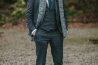 a modern fall or winter groom’s look with a three-piece pantsuit, a white shirt and a green tie plus black shoes and a scarf