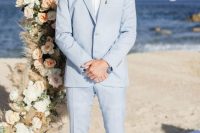 a neutral modern coastal look with a pale blue suit, a white shirt, white shoes and not tie, a pink boutonniere is amazing