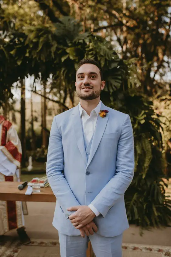 A pretty groom's look with a pale blue three piece suit, a white shirt, a bold boutonniere is amazing for spring or summer