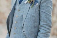 a pretty light blue three-piece linen pantsuit, a white shirt, a navy tie and a boutonniere for a coastal wedding