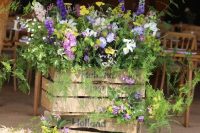 a pretty rustic summer decoration of crates, bright blooms and greenery is a stylish and cool idea to rock