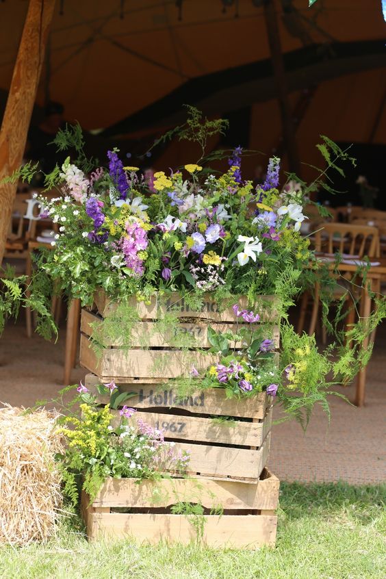 a pretty rustic summer decoration of crates, bright blooms and greenery is a stylish and cool idea to rock