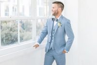 a pretty spring groom’s look with a light blue three-piece suit, a white shirt, a navy bow tie, brown shoes is elegant and cool