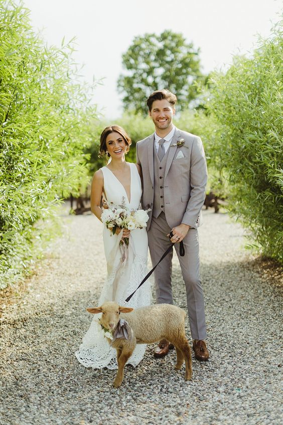 a relaxed light grey groom's look with a three-piece pantsuit, brown shoes and a grey tie, a boutonniere for spring or summer