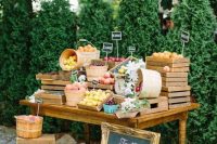 a rustic food station composed of a vintage table with crates, a chalkboard sign, some fruit and veggies is amazing