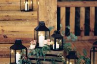 a rustic wedding decoration of crates, greenery, pastel blooms, candle lanterns is amazing for a rustic wedding