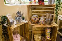 a simple and relaxed candy bar of crates, greenery in pots and some candies in jars will be a nice idea for a rustic wedding