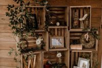 a simple rustic wedding decoration fo crates, wooden letters, greenery, photos, decor and some other stuff