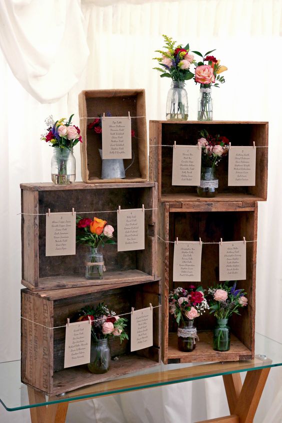 a simple rustic wedding seating chart of crates, floral arrangements and table cards is amazing for a rustic wedding