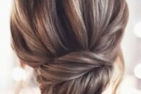 a stylish and chic French twist updo with a voluminous top and a pretty twisted chingon plus locks