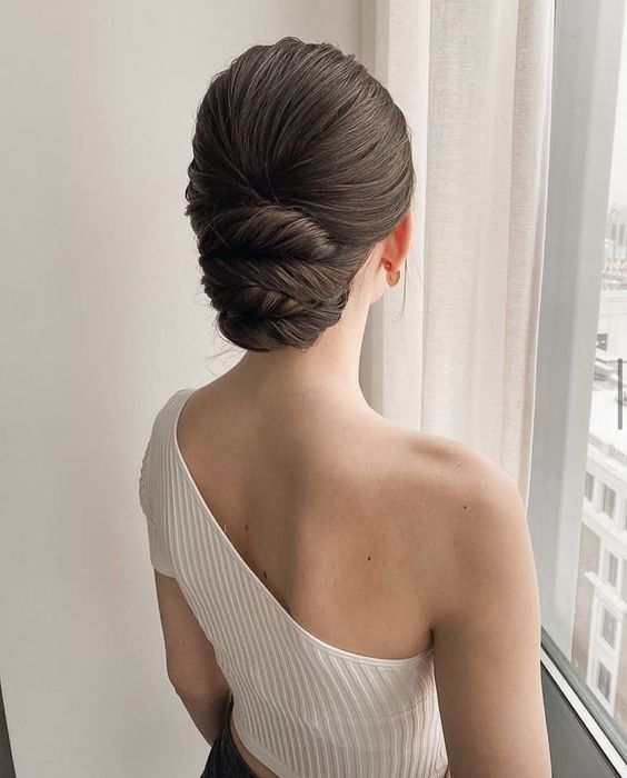 a stylish and elegant twisted low updo with a sleek top is a cool idea for a refined mother of the bride look