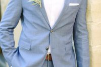 a stylish blue suit, a white shirt, a navy printed bow tie and a boutonniere are a cool combo for spring or summer