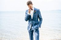 a stylish coastal groom’s outfit with a blue suit, a white shirt, a burgundy bow tie, brown shoes and a boutonniere