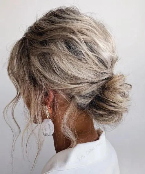 a twisted and messy low bun with a messy volume on top and some waves down help to pull off that effortless chic