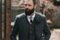 a vintage groom outfit with a grey tweed three-piece suit with copper buttons, a white shirt, a moody floral tie